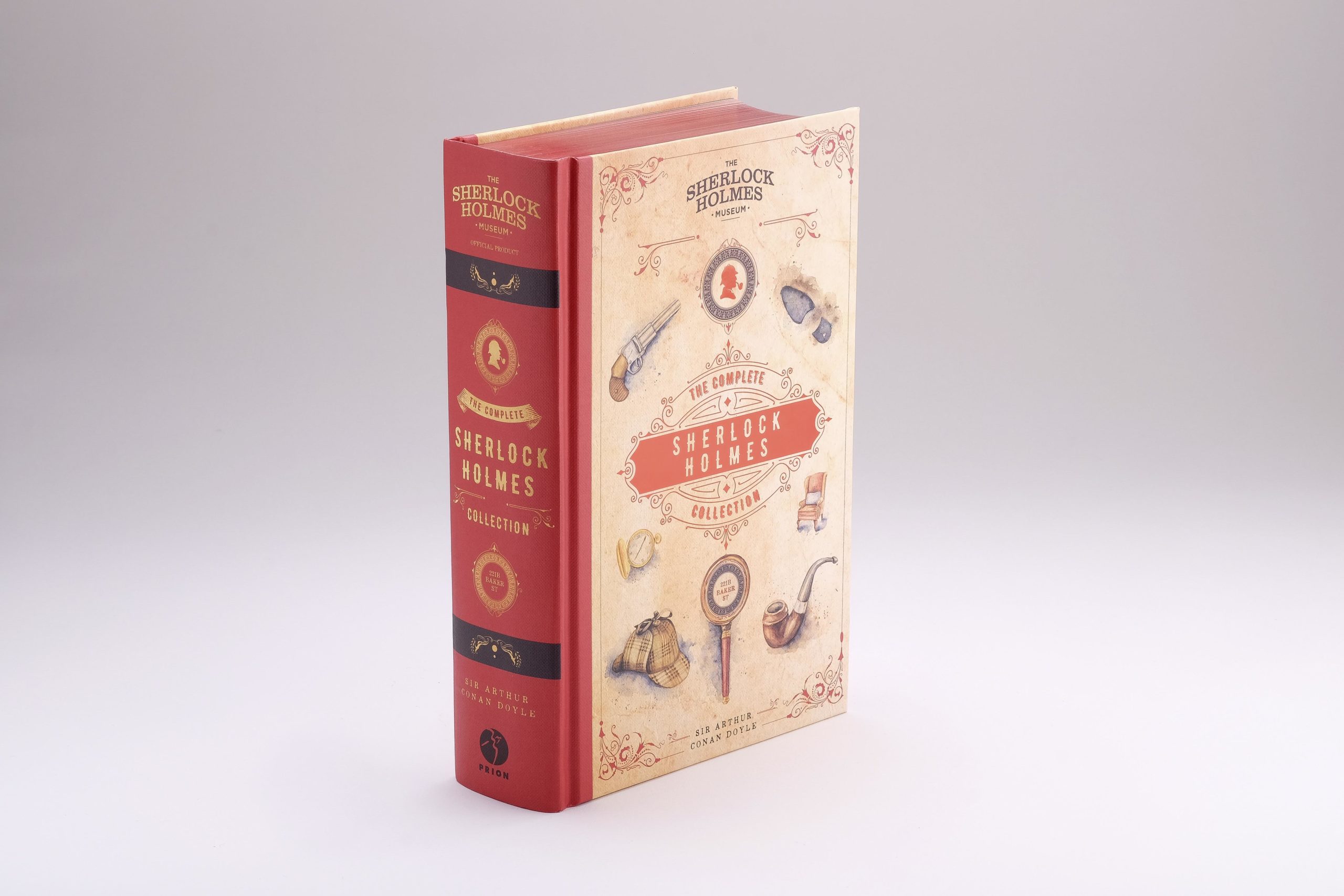 A closed copy of the complete collection book, a cream cover with red spine